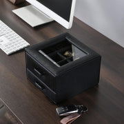 a desk with a computer and a watch on it