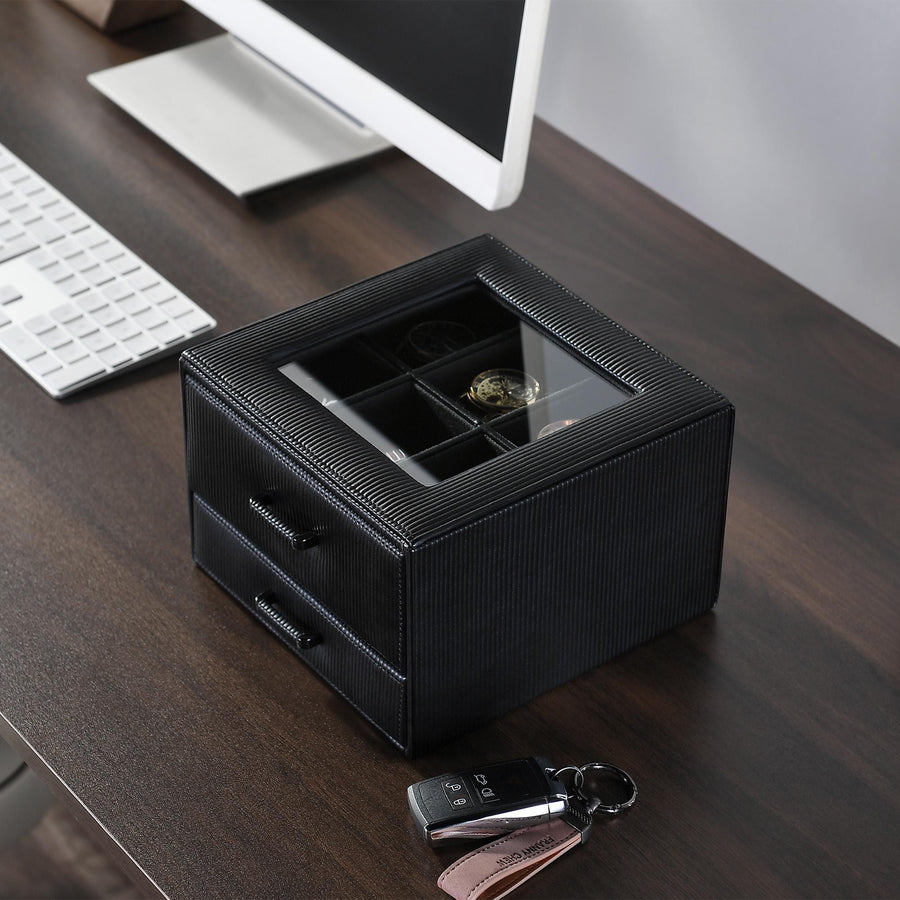 a desk with a computer and a watch on it