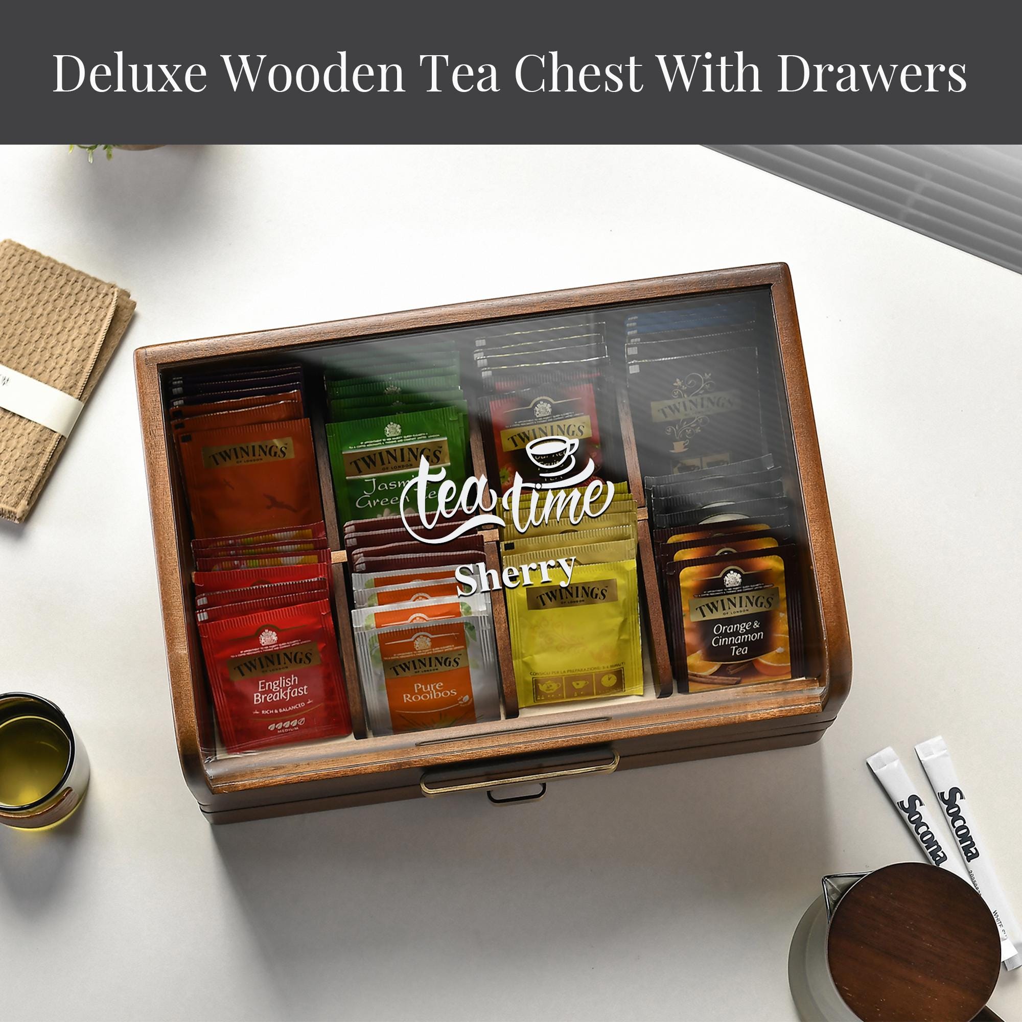 A wooden tea chest with drawers filled with various tea bags, placed on a white surface.