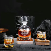 a bottle of whisky sitting on top of a table next to two glasses