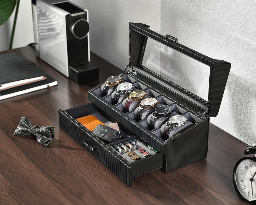a watch and watch box sitting on a desk next to a clock