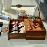 a person is holding a tray with a variety of teas