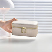 a woman's hand is holding a white suitcase