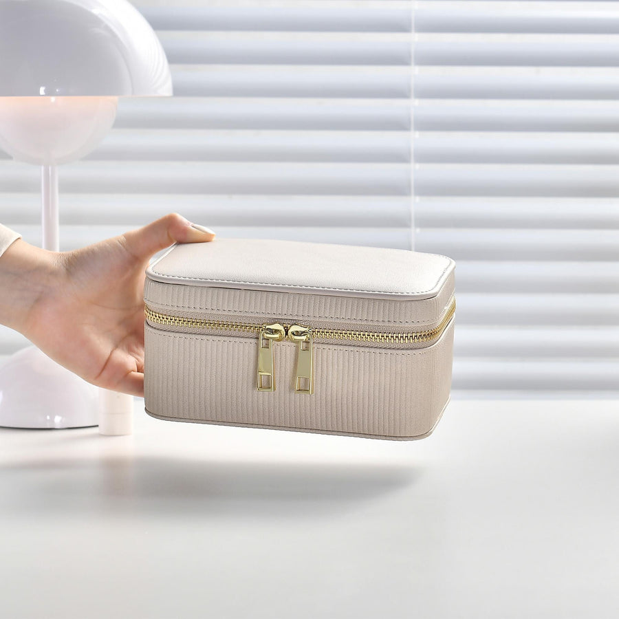 a woman's hand is holding a white suitcase