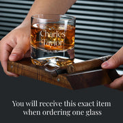 a person holding a glass with a cigar in it