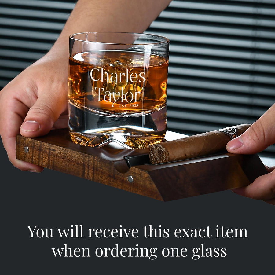 a person holding a glass with a cigar in it