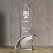 a clear glass trophy on a wooden table