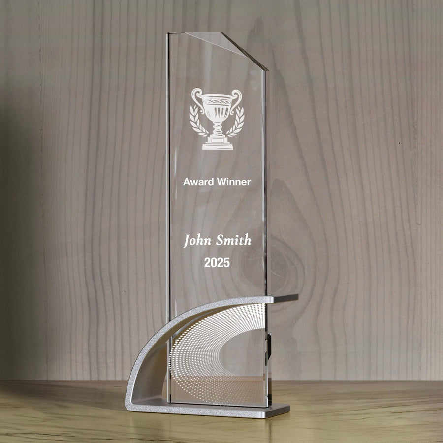 a clear glass trophy on a wooden table