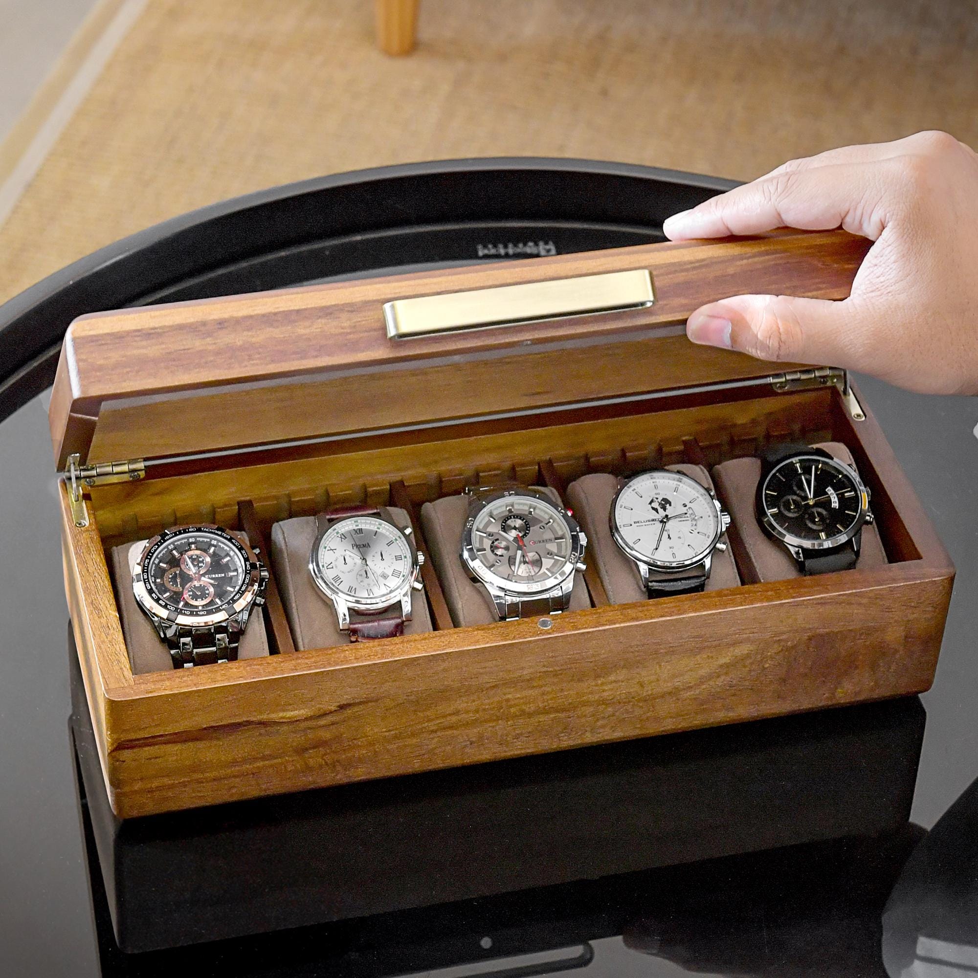 a person holding a watch in a wooden box