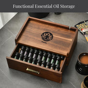 A wooden drawer with a lid, containing various bottles of essential oils, and a cup of what appears to be tea or coffee on the side.