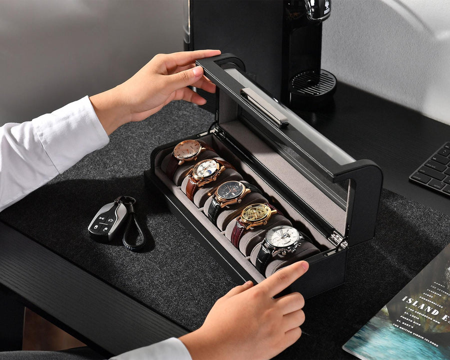 a person opening a watch box on a desk