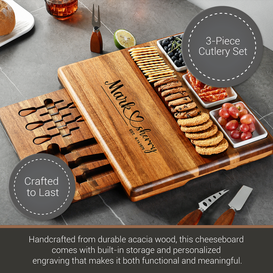 A wooden cheeseboard with a 3-piece cutlery set, featuring a personalized engraving, is displayed on a gray countertop.
