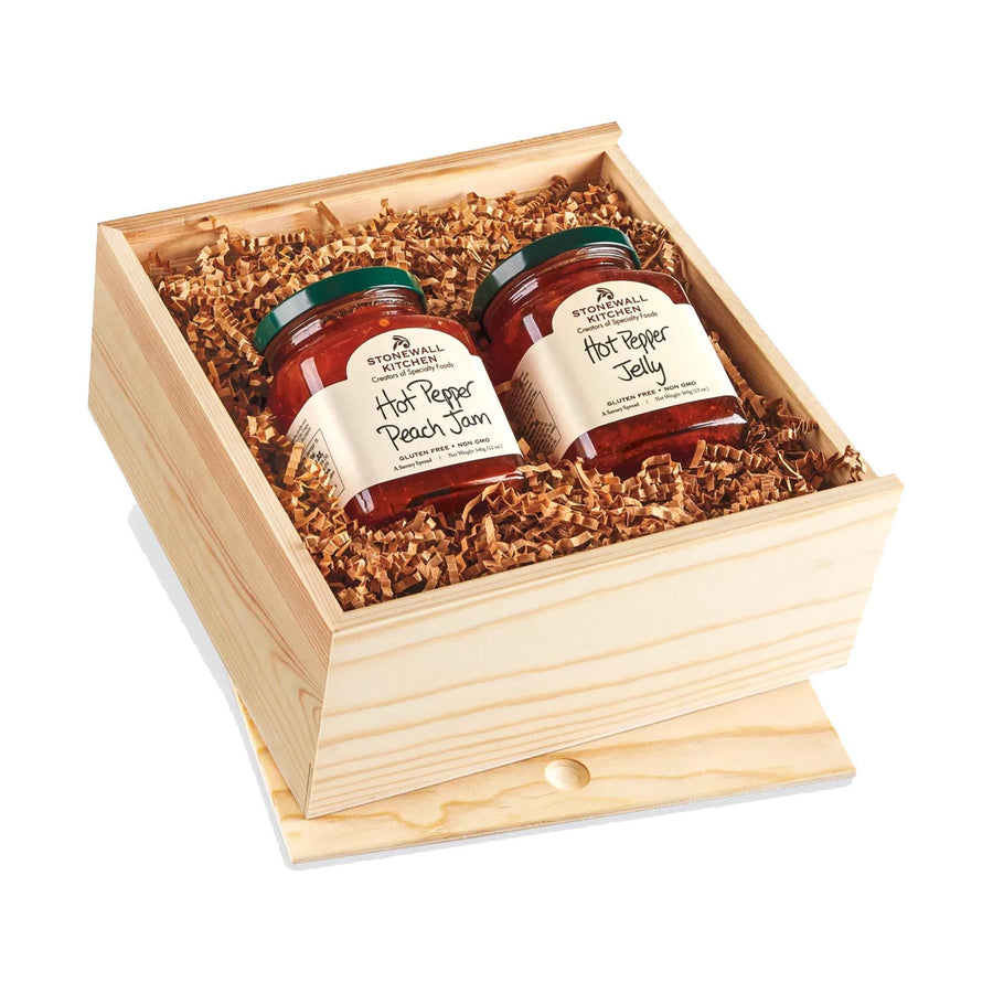 A wooden box containing two jars of hot pepper jelly, with a lid and a wooden tray on top.