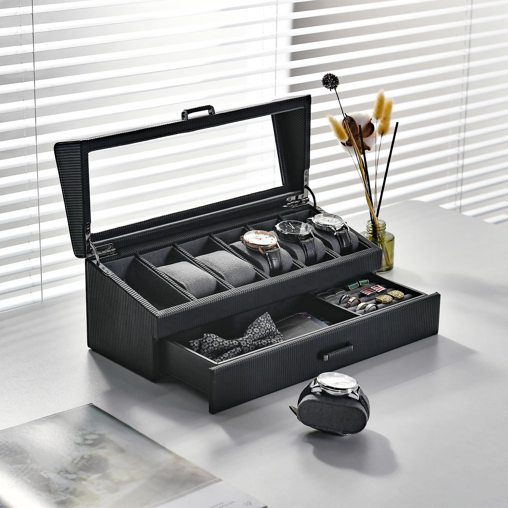 a watch and tie in a black case on a table
