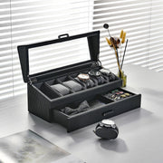 a watch and tie in a black case on a table