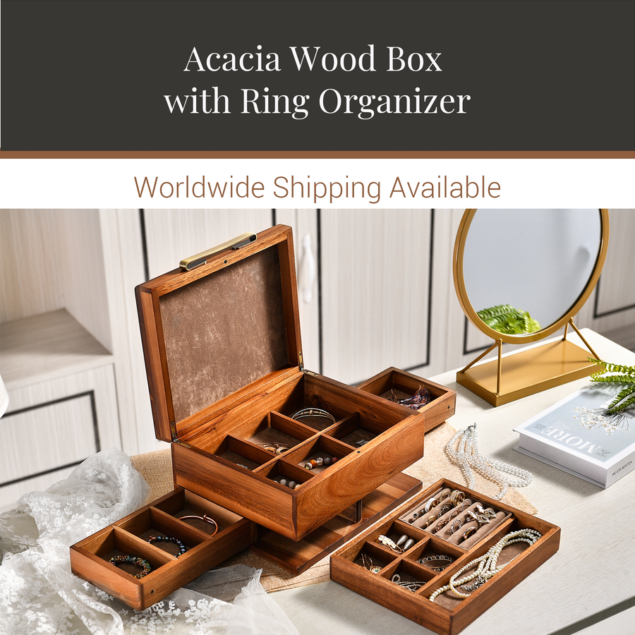 a wooden jewelry box with multiple compartments, showcasing various pieces of jewelry. The box is placed on a table, and there is a mirror and a book nearby. The image also includes text that reads "Acacia Wood Box with Ring Organizer" and "Worldwide Shipping Available".