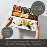 a wooden serving board with various food items, including crackers, cheese, fruit, and meats, arranged in three ceramic bowls. The board also includes a hidden drawer for additional serving tools.