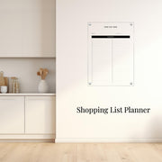 a white kitchen counter with a vase of spoons, a shopping list planner hanging on the wall, and a wooden floor.