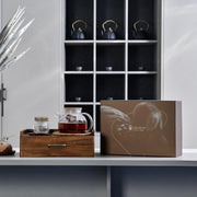 a table with a box of tea and a vase