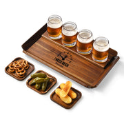 A wooden tray with four glasses of beer, three small plates with snacks, and a logo on the tray.