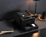 a table with a lamp and a black box on it