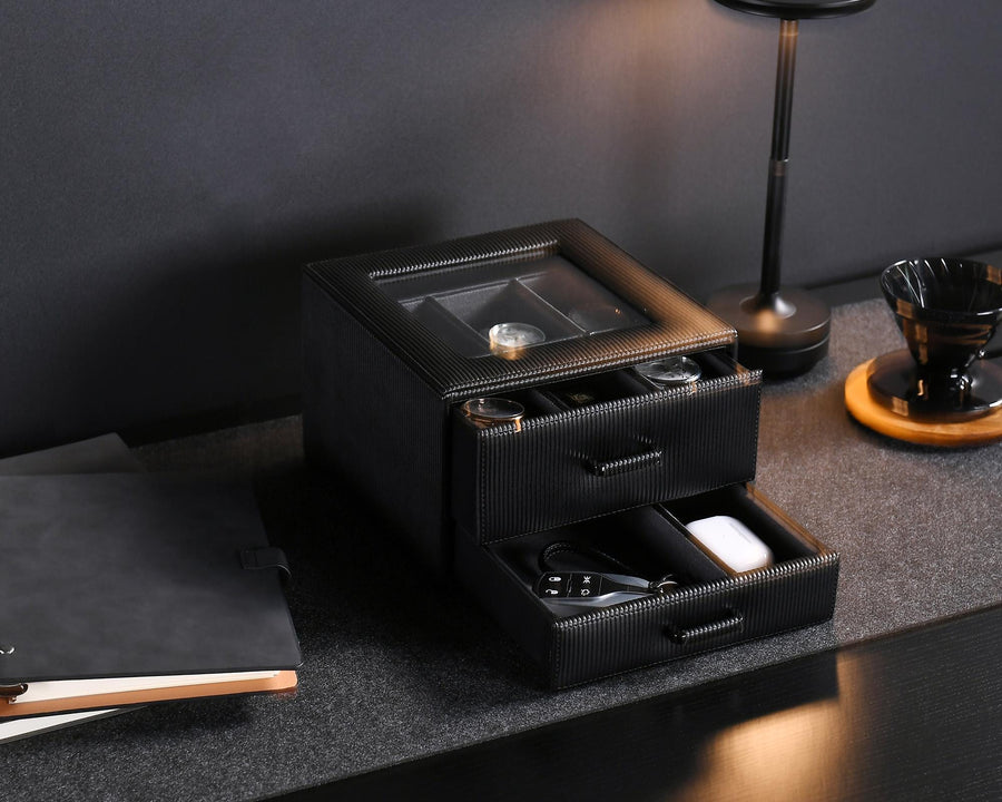 a table with a lamp and a black box on it