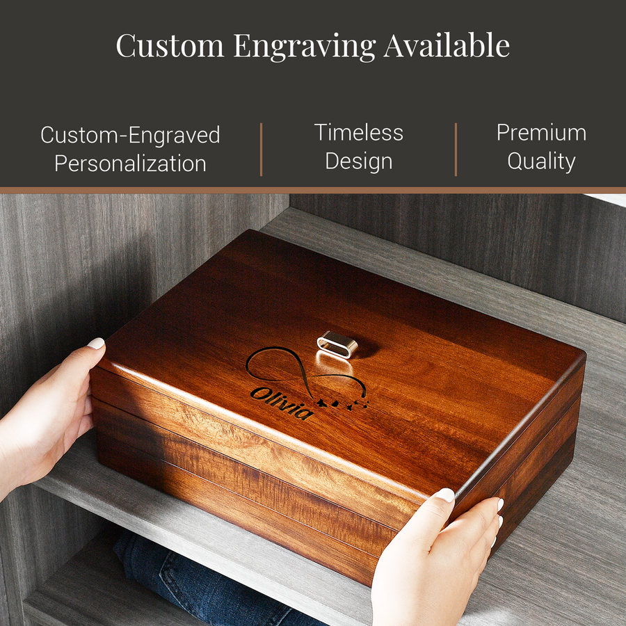 A person's hands are holding a wooden box with a custom engraving on it, which features the name "Olivia" and a heart symbol. The box is described as having custom engraving available, suggesting it is a personalized item.