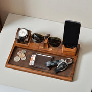 a wooden tray with a cell phone, sunglasses, money and a watch