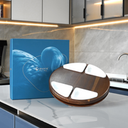 a wooden and white stand with a blue box with a picture of a bird on it, placed on a white countertop in a kitchen setting.