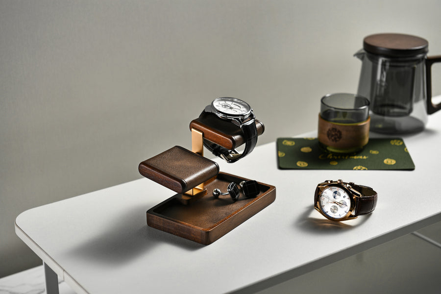 a collection of watches and a coffee pot on a white table.