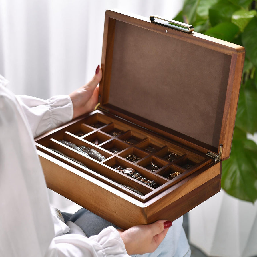 a woman holding a wooden jewelry box filled with jewelry