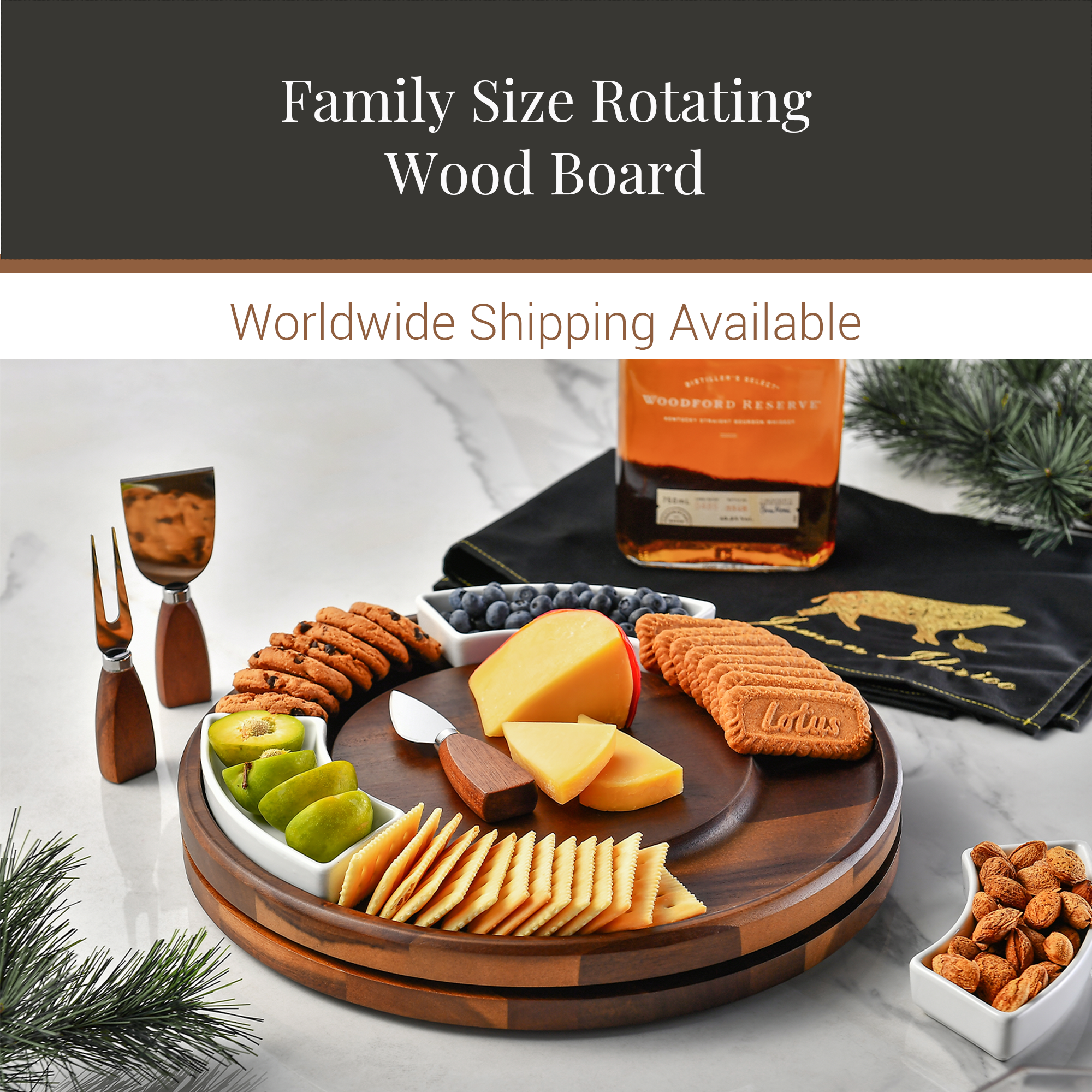 a wooden rotating board filled with various snacks and cheeses, including crackers, cookies, and cheese slices, along with a bottle of whiskey and a black cloth with a gold logo.