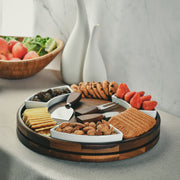 A wooden platter filled with an assortment of snacks, including crackers, cookies, and strawberries, is displayed on a table.