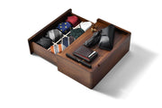 a wooden drawer with various accessories neatly organized inside, including ties, a wallet, and a pen.