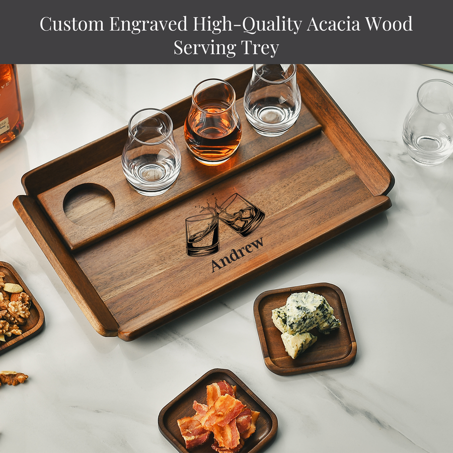 A wooden serving tray with a custom engraved design, featuring a pair of glasses and a name, Andrew, on it. The tray is accompanied by various food items, including a plate of bacon, a plate of cheese, and a plate of nuts.