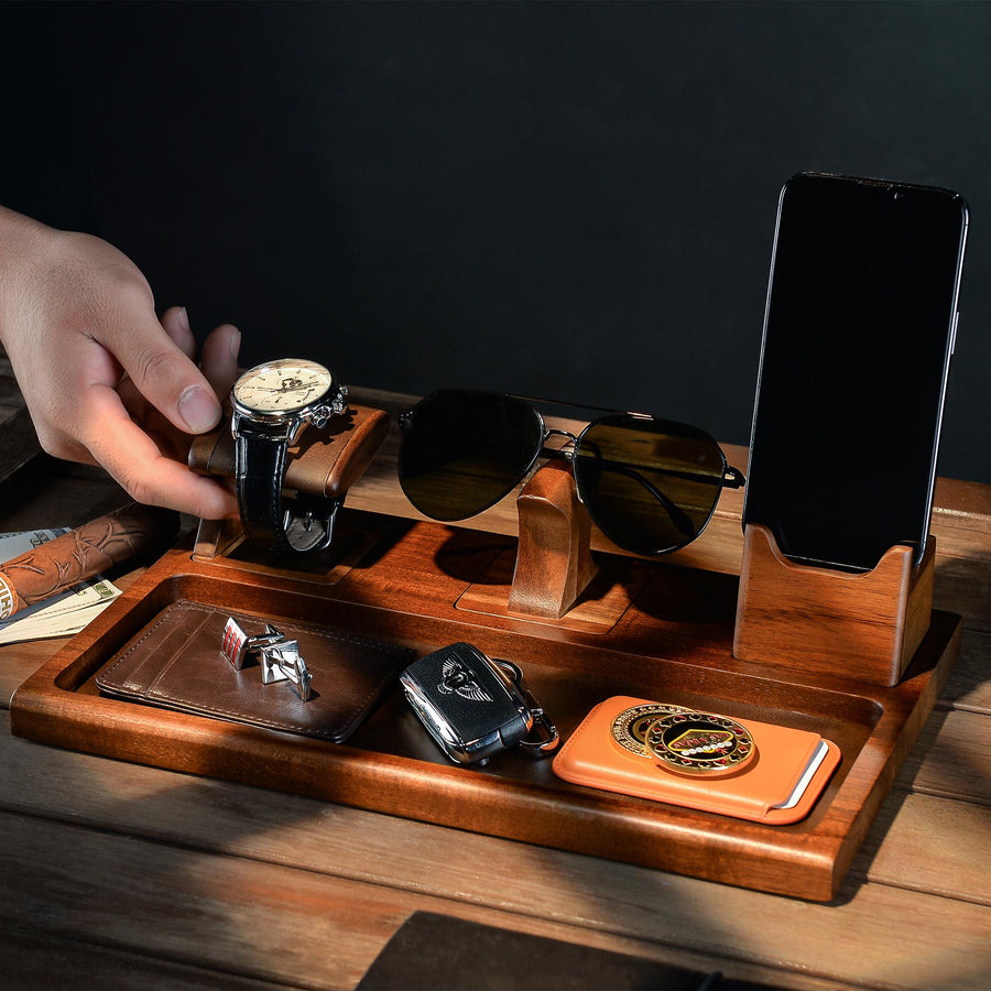 a person putting a watch on top of a wooden tray