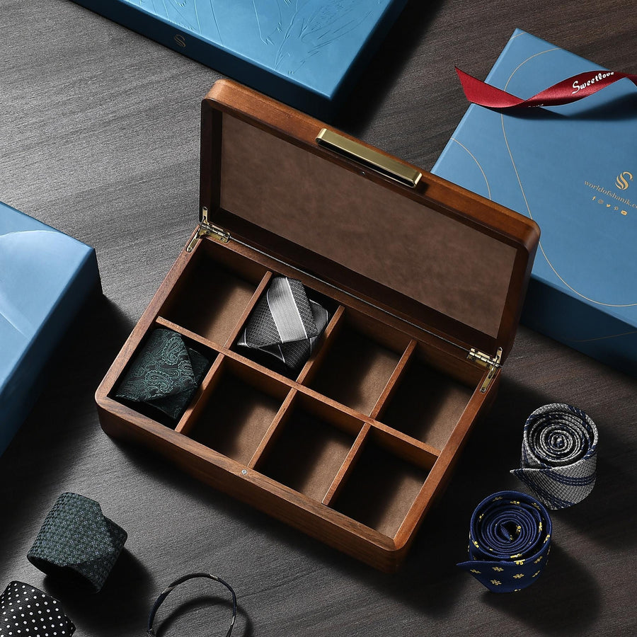 a wooden box containing a tie and a pair of scissors