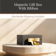a black gift box with a gold ribbon, placed on a white pedestal.