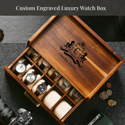 A wooden watch box with a personalized monogrammed logo, containing various watches and a camera.