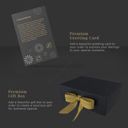 a black box with a gold ribbon and a greeting card