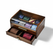 A wooden drawer with multiple compartments, displaying a variety of colorful ties.