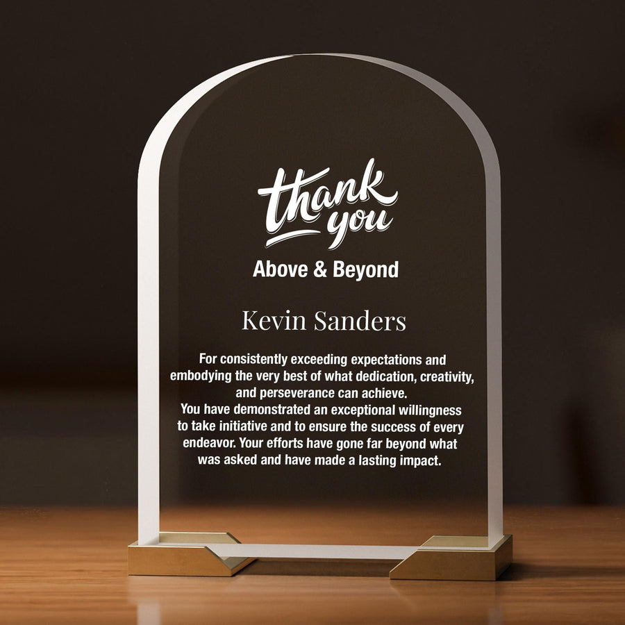 a clear glass award with a gold base