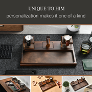 The image showcases a wooden watch stand with three watch faces on it, accompanied by a keyboard, a cup, and a plant. The text above the image reads "UNIQUE TO HIM personalization makes it one of a kind".