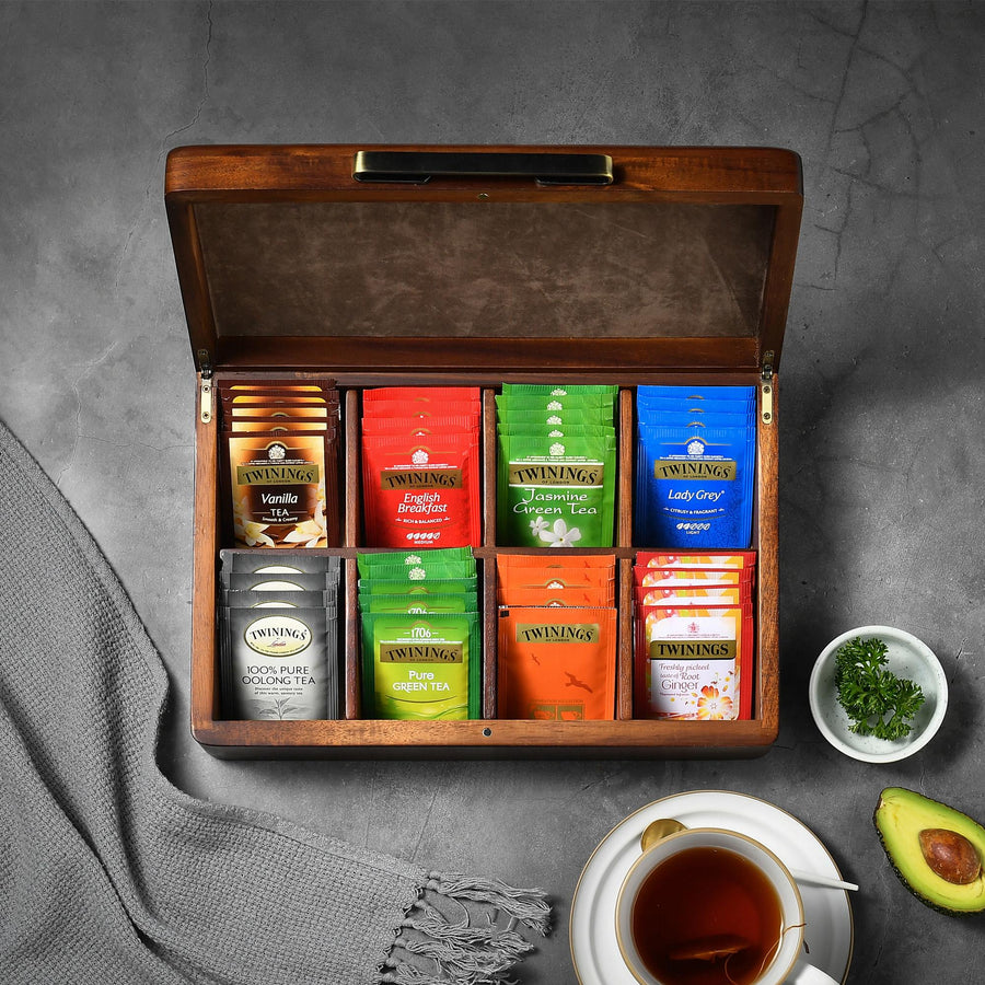 a cup of tea next to a box of tea and an avocado