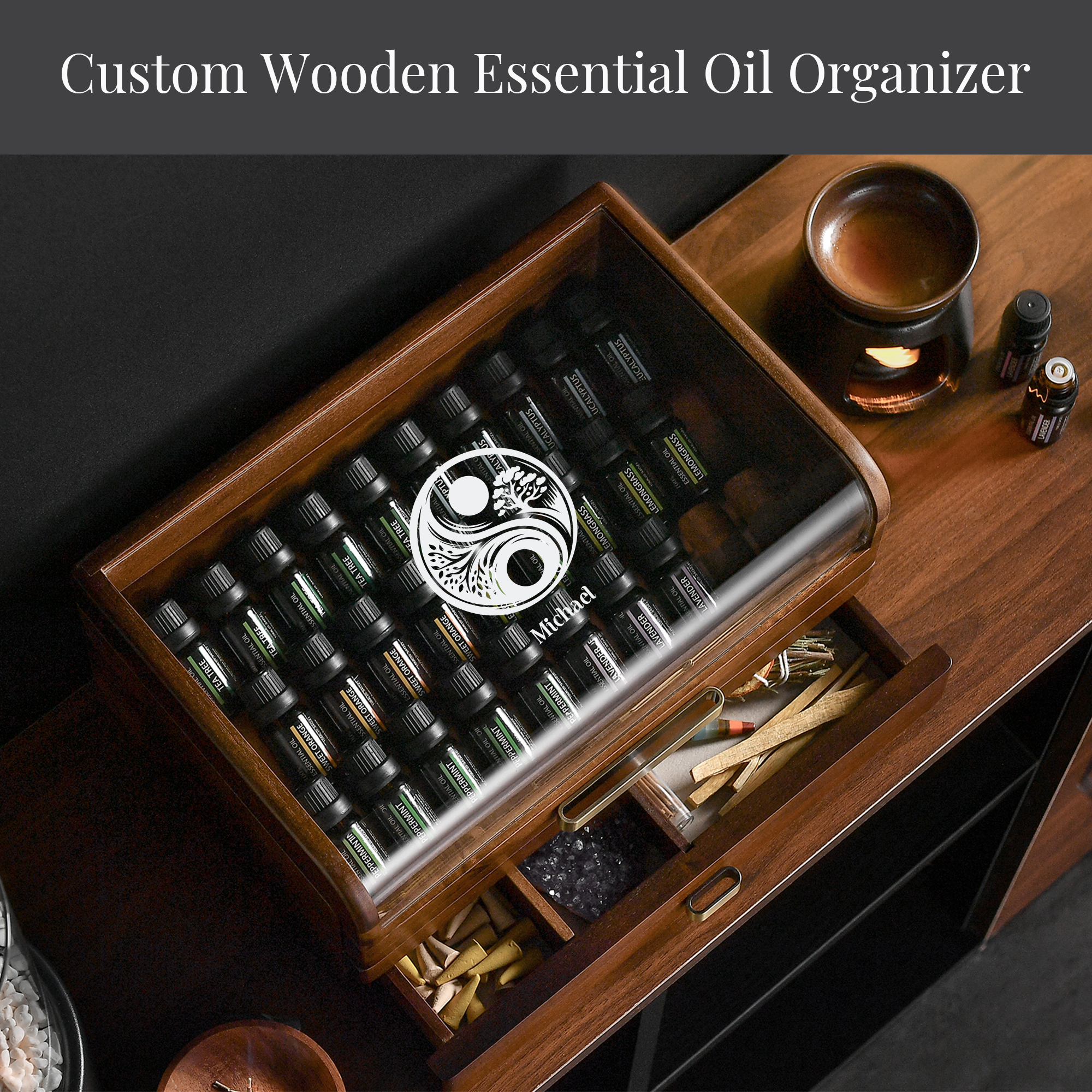A wooden essential oil organizer with various bottles of essential oils inside, along with a small glass container and a candle on a wooden surface.