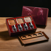 a set of four wine glasses in a red box, with a wooden tray below them.