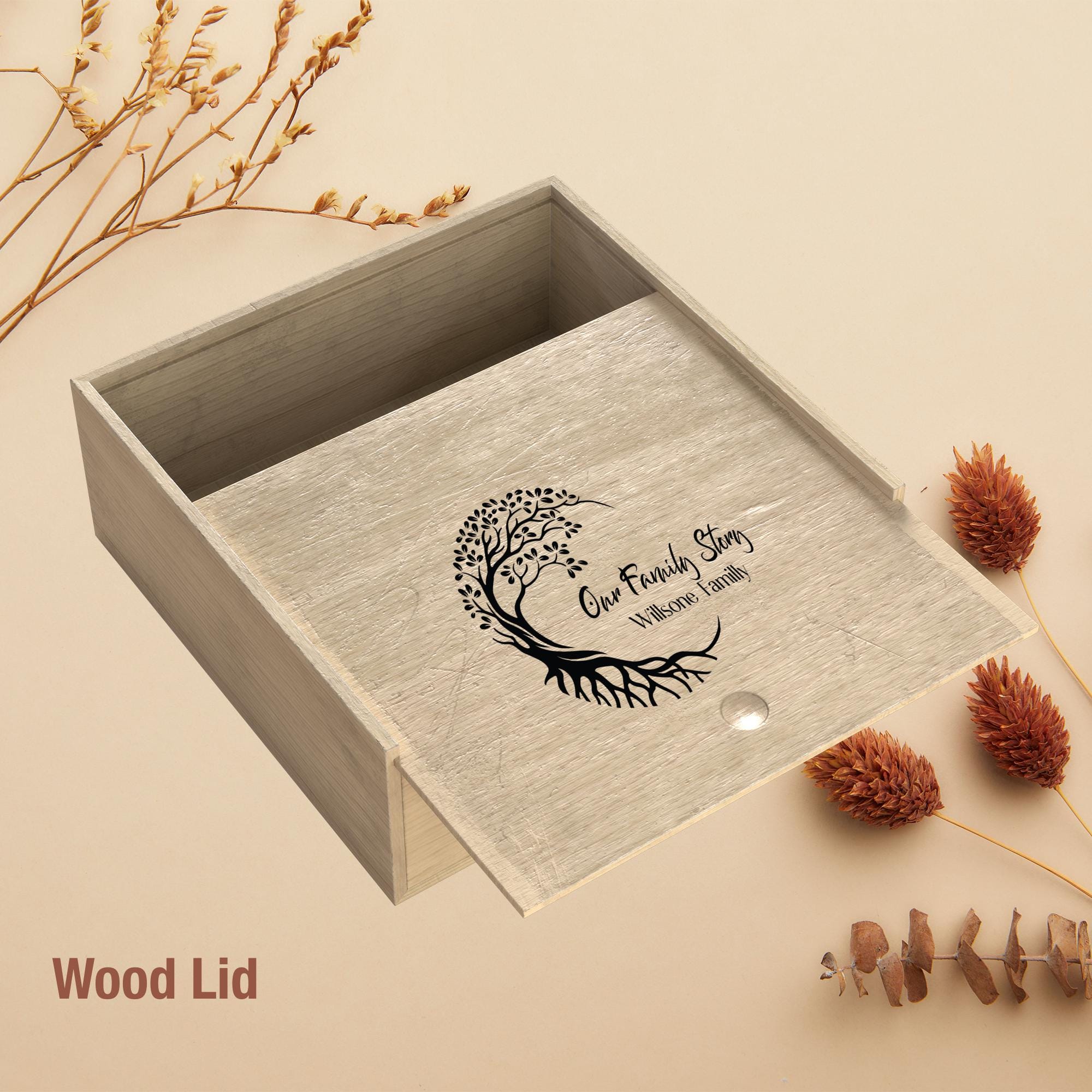a wooden box lid with a tree design and the text "Our Family Story" printed on it, along with some dried flowers and pine cones.